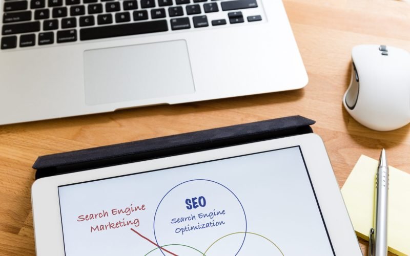 Business working desk with tablet showing search engine marketing concept